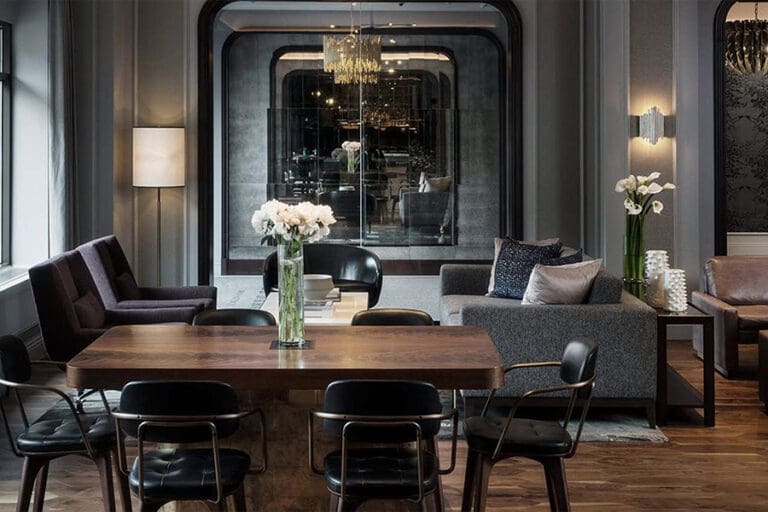 Hotel lobby lounge with black chairs around a wood table
