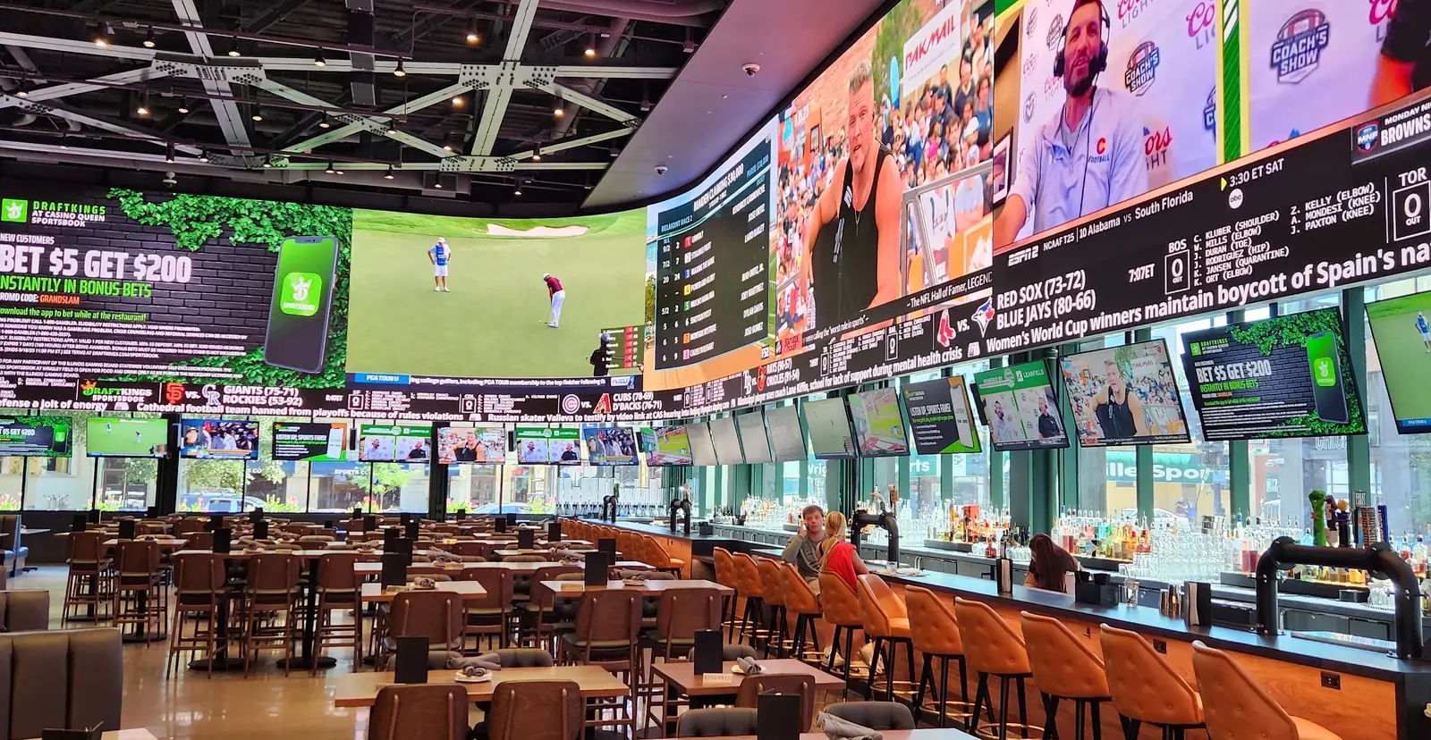 Bar stools and dining seating at the DraftKings at Casino Queen sportsbook