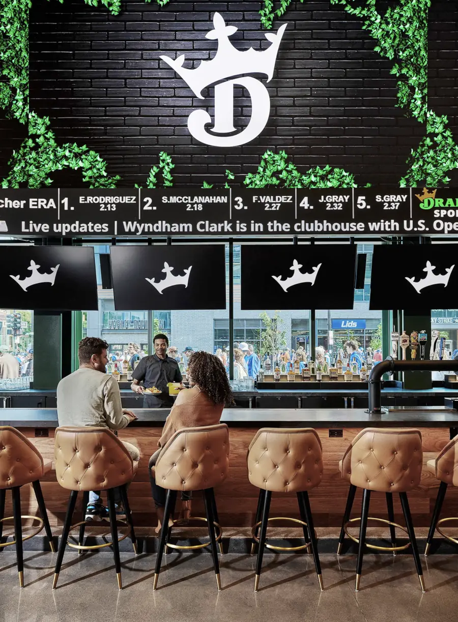 Tufted Encore Stools with brass footrings at a DraftKings Sportsbook bar
