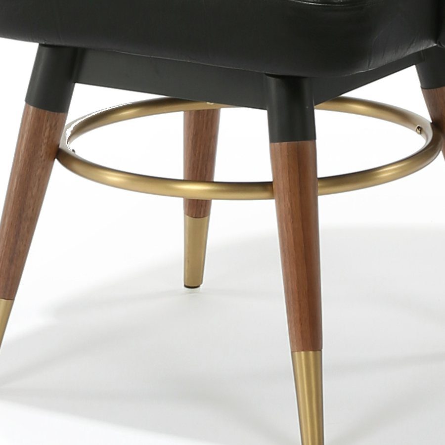 Close-up of brass-capped walnut legs and brass footring on the Encore Chair.